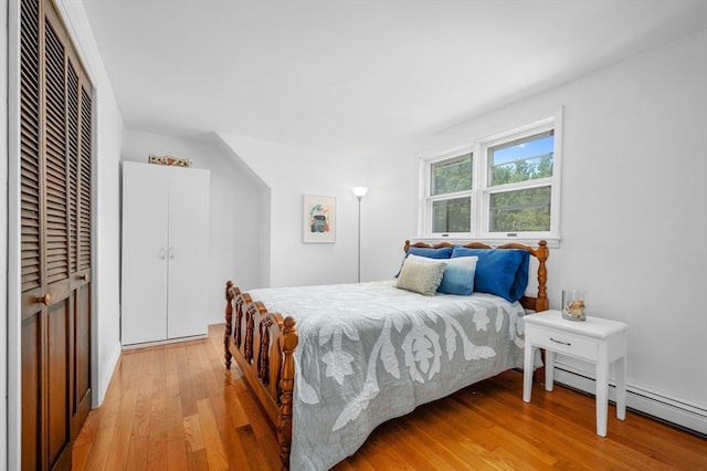 bedroom featuring baseboard heating and light wood-type flooring