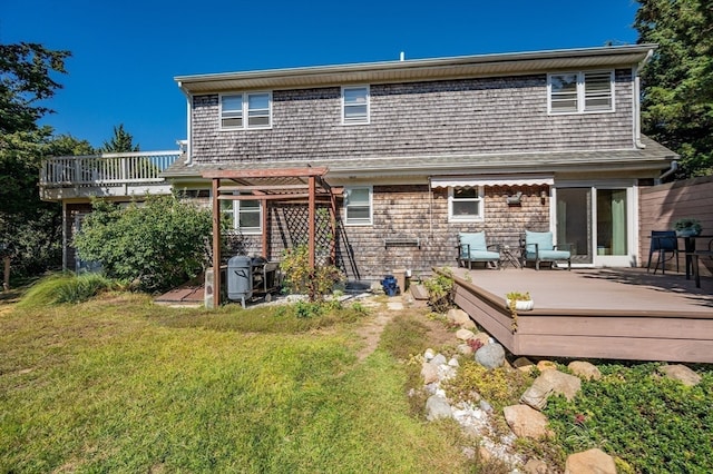 back of house featuring a deck, a lawn, and a pergola