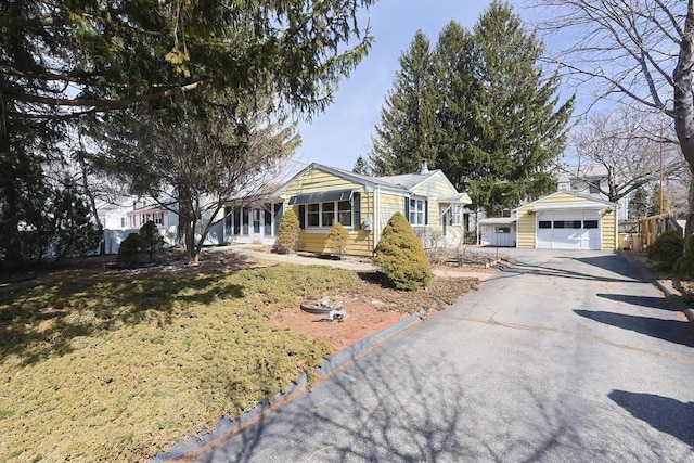 view of front of house featuring a garage, driveway, and an outdoor structure