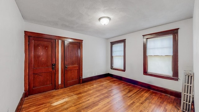 235-237 Corey Rd, Boston, MA 02135 - spare room featuring radiator heating unit and light wood-style flooring