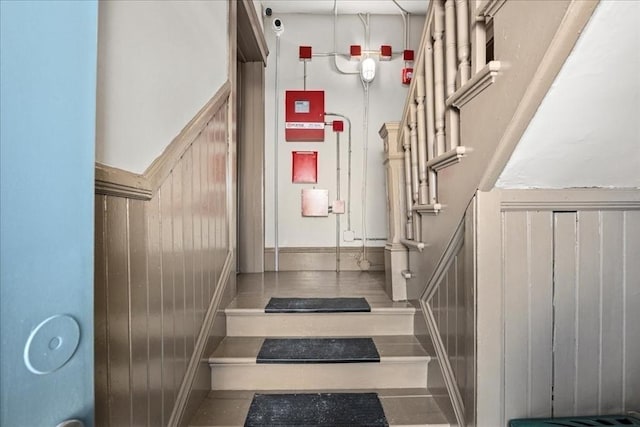 staircase featuring wooden walls