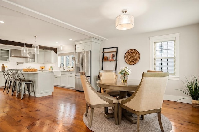 dining space featuring recessed lighting, plenty of natural light, baseboards, and hardwood / wood-style flooring