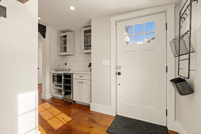 interior space featuring beverage cooler, baseboards, wood finished floors, and recessed lighting