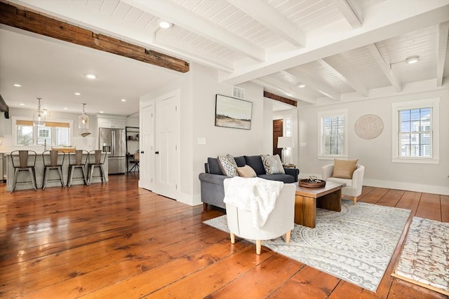 living area featuring visible vents, baseboards, wood-type flooring, beam ceiling, and recessed lighting