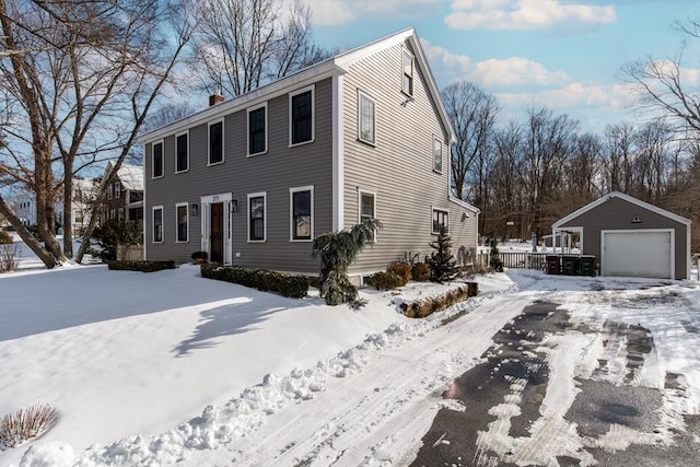 view of front of home with an outbuilding, a detached garage, and a chimney