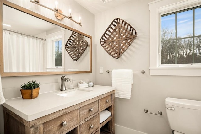 full bathroom with a healthy amount of sunlight, vanity, and toilet