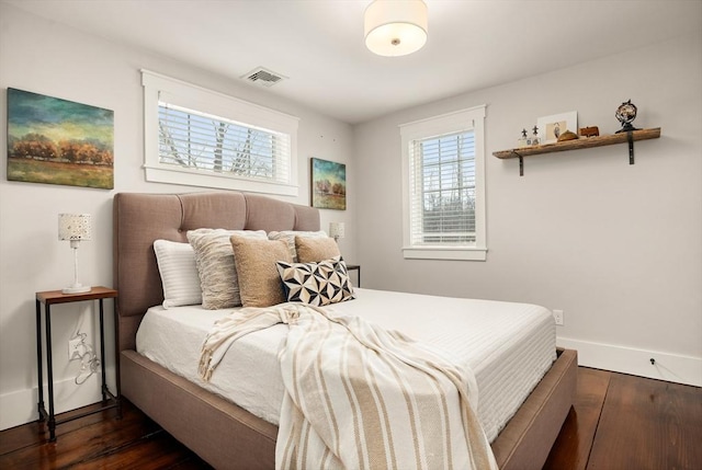 bedroom featuring dark wood-style floors, visible vents, and baseboards