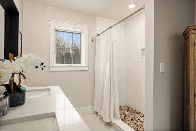 bathroom with a stall shower, vanity, baseboards, and tile patterned floors