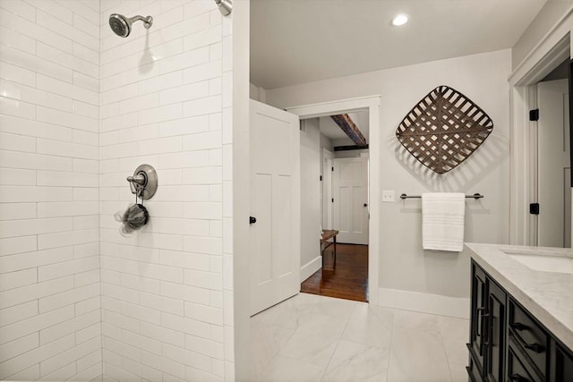 full bath featuring recessed lighting, vanity, baseboards, marble finish floor, and tiled shower