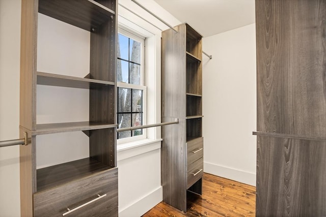 walk in closet with wood finished floors