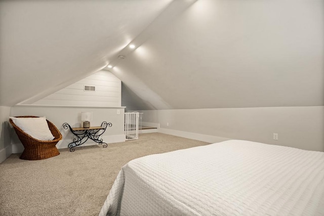 carpeted bedroom with lofted ceiling, baseboards, and visible vents