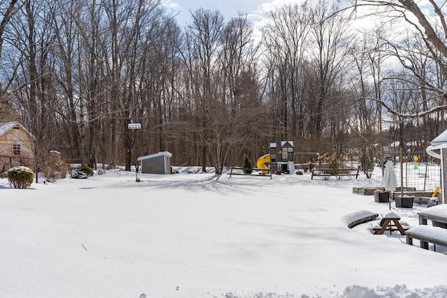 yard covered in snow with a playground