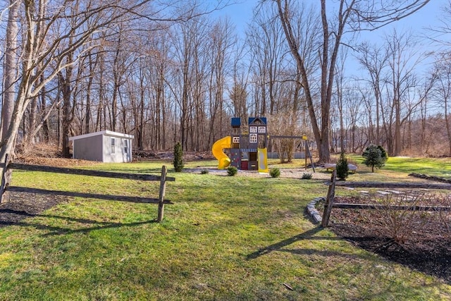 view of yard featuring a playground, an outdoor structure, and a storage shed