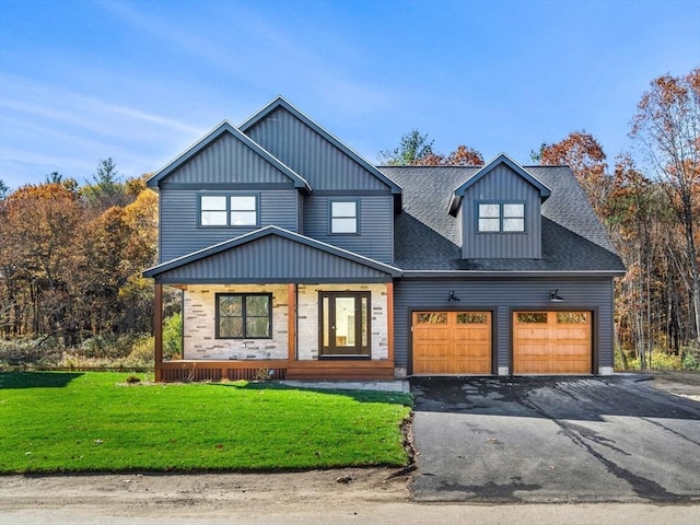 view of front of house featuring a front yard, a porch, and a garage