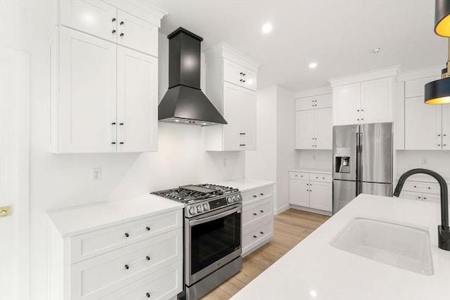 kitchen with stainless steel appliances, white cabinetry, wall chimney exhaust hood, and sink