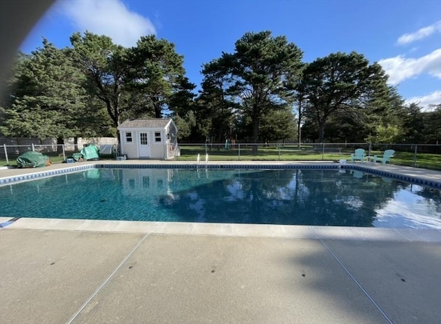 view of pool with fence, an outdoor structure, and a fenced in pool
