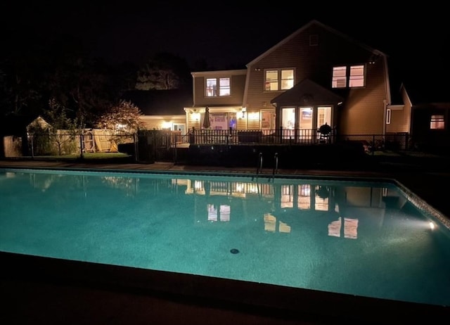 pool at twilight featuring a fenced in pool and fence