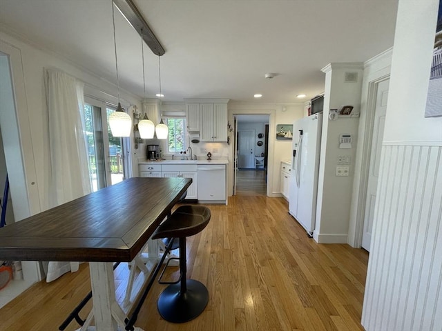 dining space with crown molding, light wood finished floors, recessed lighting, and visible vents