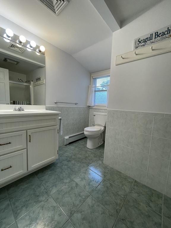 bathroom featuring a baseboard heating unit, vaulted ceiling, tile walls, vanity, and tile patterned flooring