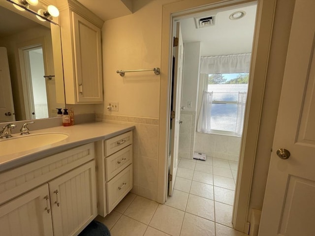 bathroom featuring tile walls, visible vents, tile patterned flooring, and vanity