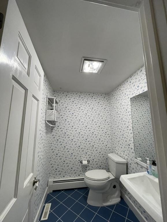 full bath featuring baseboard heating, toilet, tile patterned flooring, and a shower