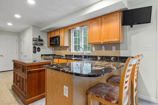 7 Suzannah Rd, Billerica, MA 01862 - kitchen with black microwave, stainless steel stove, recessed lighting, dark countertops, and a breakfast bar