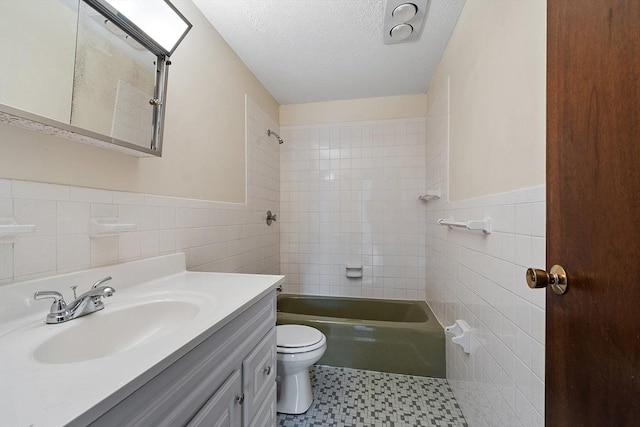 full bath featuring a textured ceiling, tile walls, shower / bathtub combination, and toilet