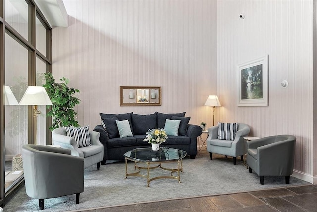 living area with stone tile flooring and a high ceiling