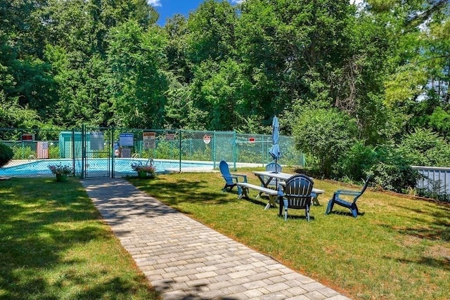 view of property's community featuring a gate, a lawn, and fence