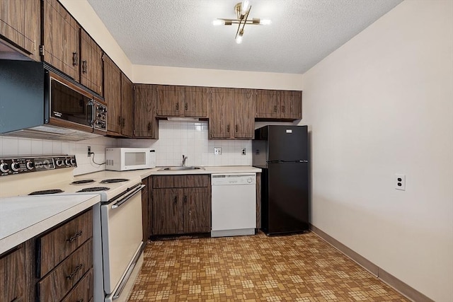 kitchen featuring backsplash, dark brown cabinetry, light countertops, black appliances, and a sink