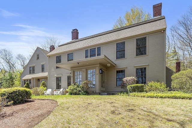 view of front of property with a chimney and a front lawn