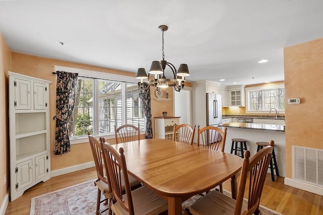 dining space featuring visible vents, an inviting chandelier, baseboards, light wood-type flooring, and recessed lighting