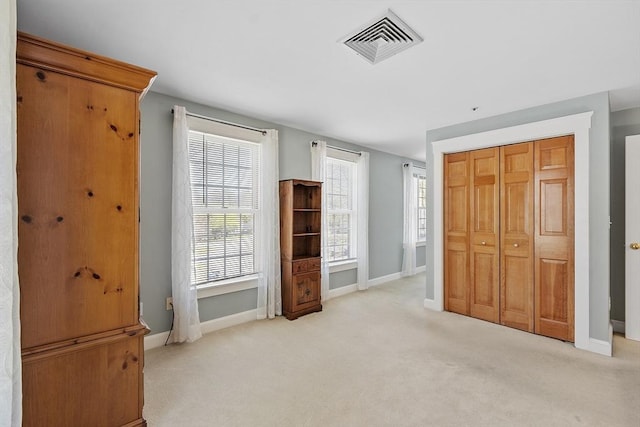 unfurnished bedroom with visible vents, baseboards, carpet floors, and a closet