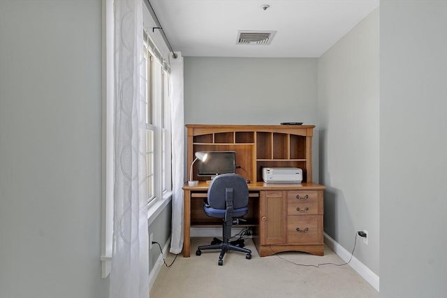 office area with visible vents, baseboards, a wealth of natural light, and light colored carpet