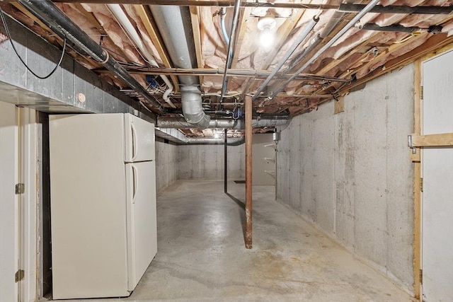 unfinished basement featuring freestanding refrigerator