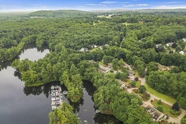 drone / aerial view featuring a water view and a wooded view