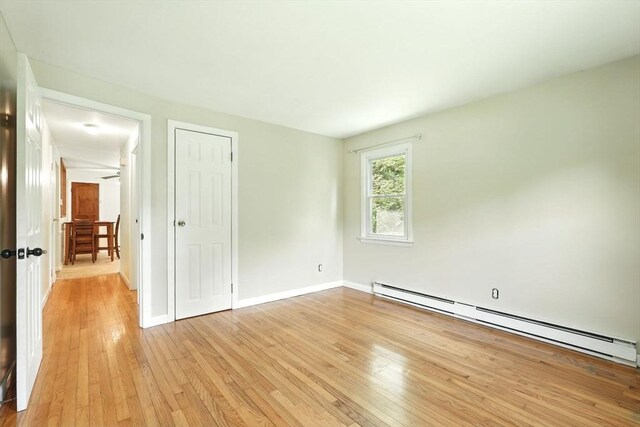 161 Farmington Rd, Amherst, MA 01002 - unfurnished bedroom featuring a baseboard heating unit, light wood-type flooring, baseboards, and a closet