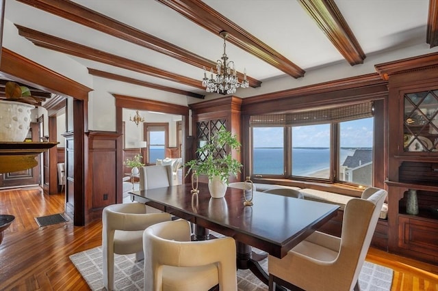 2 Bluff Rd, Hull, MA 02045 - dining room featuring a chandelier, beamed ceiling, plenty of natural light, wood finished floors, and a wainscoted wall