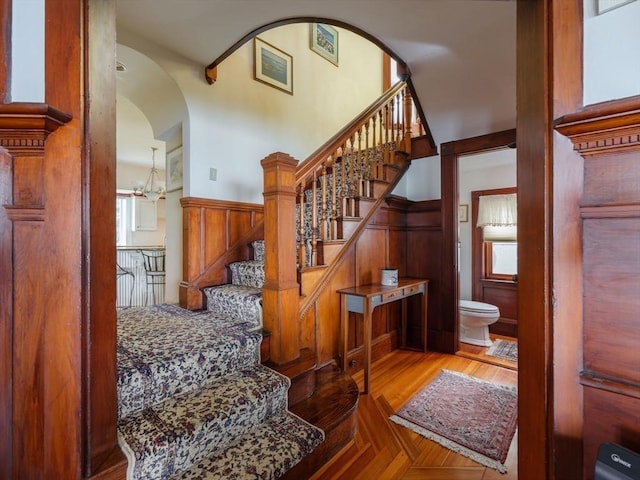 2 Bluff Rd, Hull, MA 02045 - stairway featuring arched walkways, wainscoting, and wood finished floors