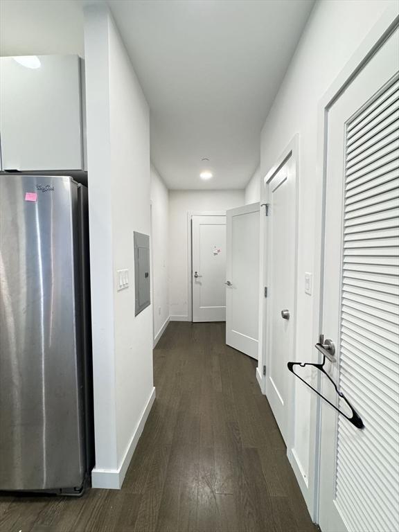 corridor featuring dark hardwood / wood-style flooring and electric panel