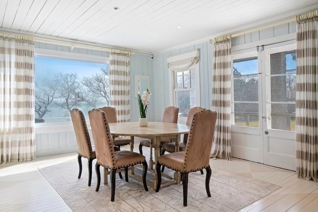 dining space featuring french doors, light hardwood / wood-style floors, and crown molding