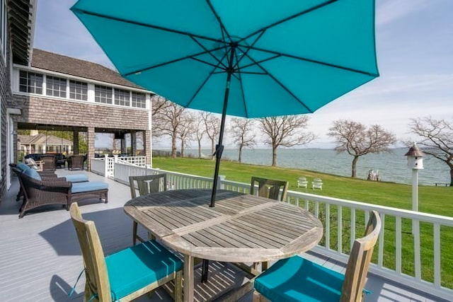 wooden deck featuring a water view and a lawn