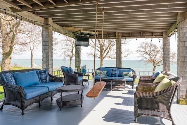 view of patio / terrace with an outdoor living space and a deck with water view