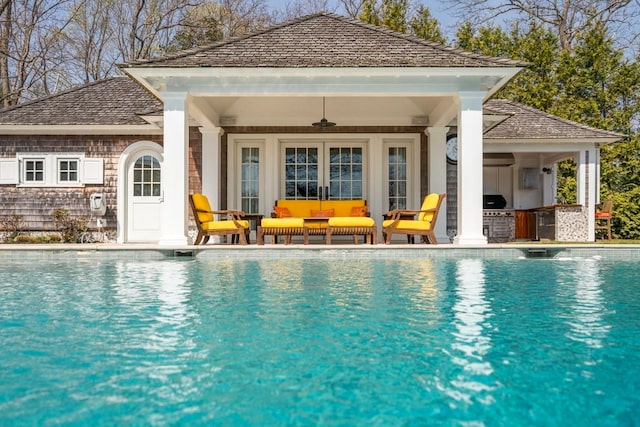 view of pool with an outdoor living space, ceiling fan, and a patio