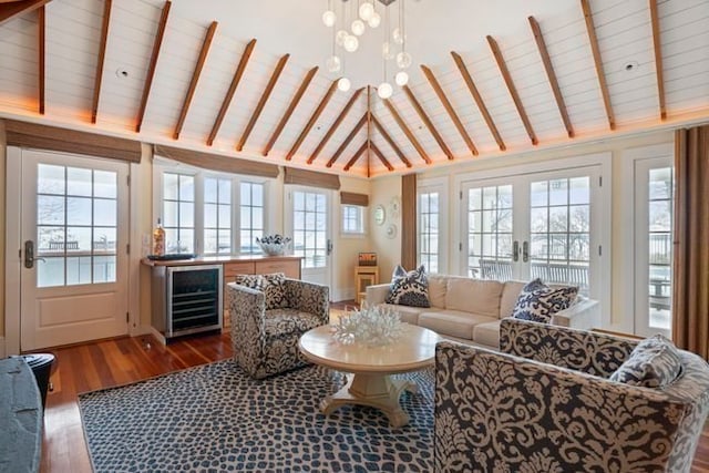 interior space with plenty of natural light, a notable chandelier, and vaulted ceiling with beams