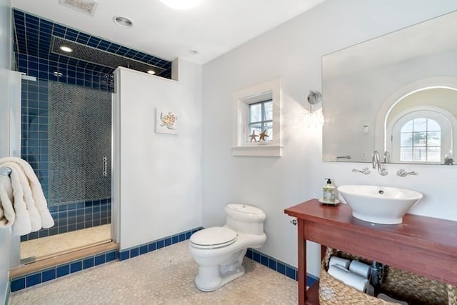 bathroom featuring walk in shower, sink, and toilet