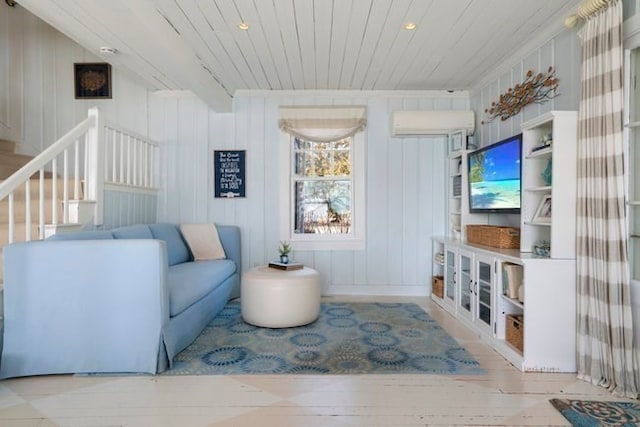 living area featuring built in shelves, an AC wall unit, light hardwood / wood-style flooring, and wooden ceiling