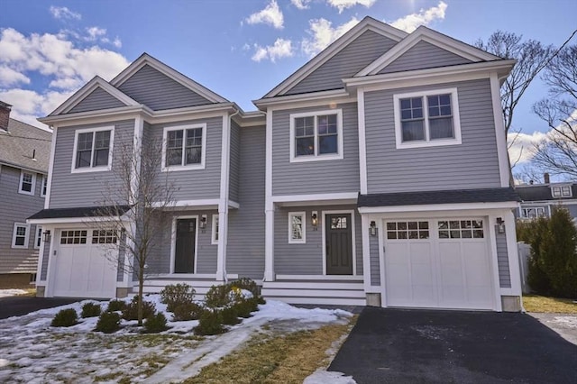 shingle-style home featuring aphalt driveway and an attached garage