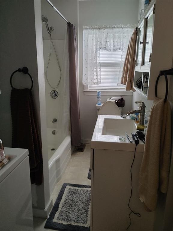 bathroom featuring washer / dryer, vanity, and shower / tub combo