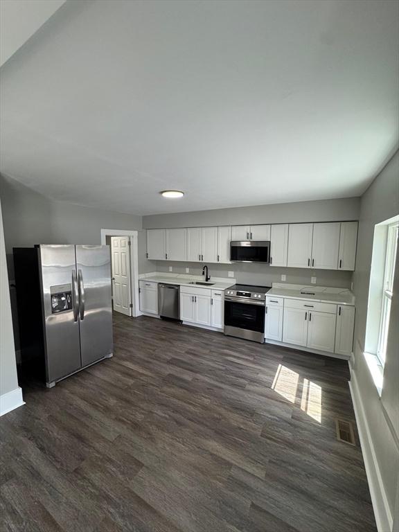 32 Main St, Monson, MA 01057 - kitchen featuring stainless steel appliances, light countertops, dark wood finished floors, and white cabinets